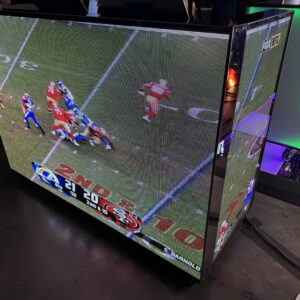 TV displaying a football game between teams with scores 21 and 20, showing a play in progress on the field.