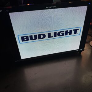 A screen displaying the Bud Light logo on a dark surface.