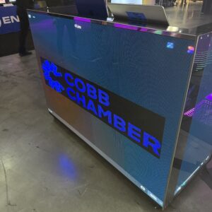 A digital display sign at an event reads "Cobb Chamber" with a blue logo.