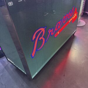A screen displaying the Atlanta Braves logo with a stylized tomahawk on a reflective surface.